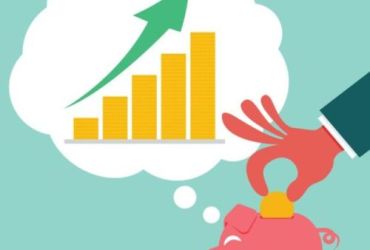 turkusowe tło a nan nim różowa świnka skarbonka i dłoń wkładająca monetę do niej w myslach świnki widać słupki rosnące do...